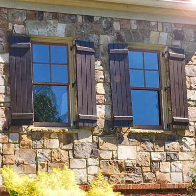 Brown PVC Outdoor Shutters on a Stone Home