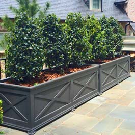 long, custom grey planter with X pattern design on front