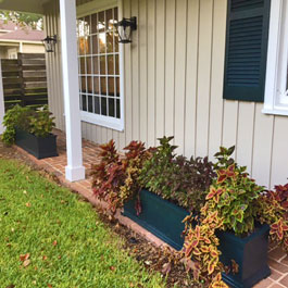 Black porch planters between porch columns