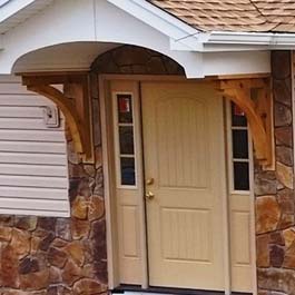 Large door portico held up with cedar bracket supports