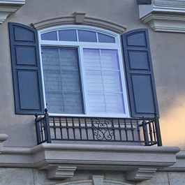 raised panel shutters with three panels on stucco home balcony