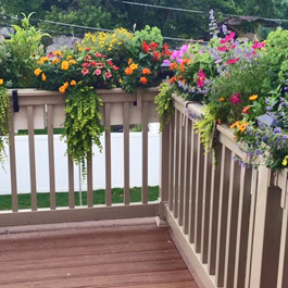 beige deck rail planters with hooks on corner of railing