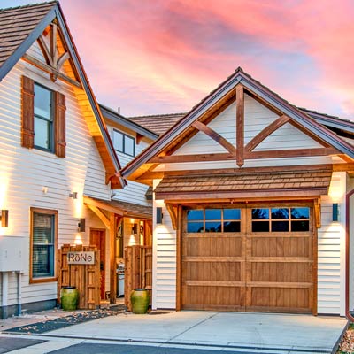 Red western cedar wood home detailed with brackets, rafter tails, decorative gables, and more.